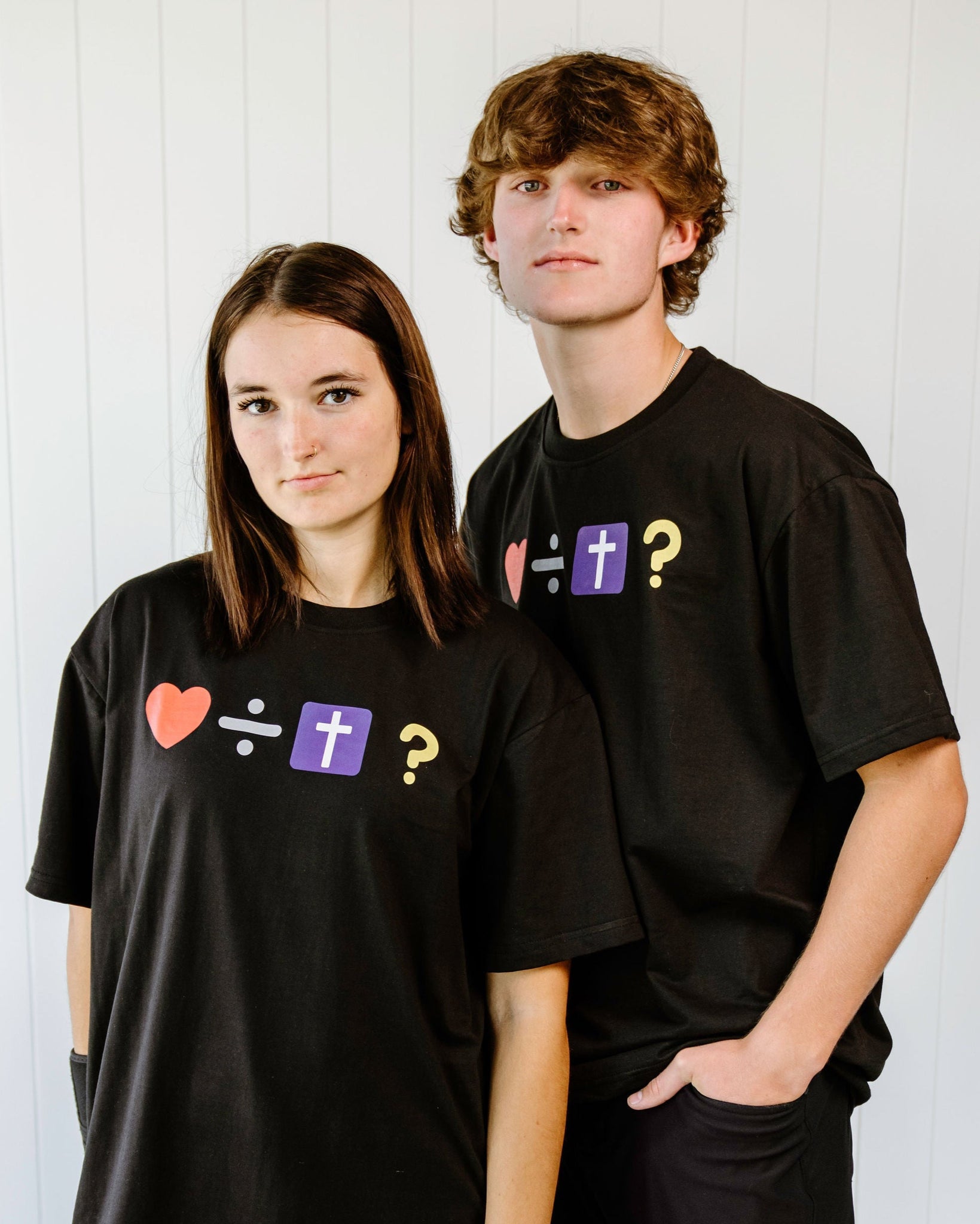 Two people wearing black t-shirts with emoji evangelism symbols