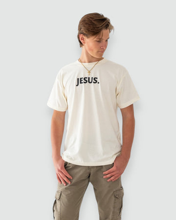 Person wearing a white t-shirt with 'JESUS.' text on a plain background