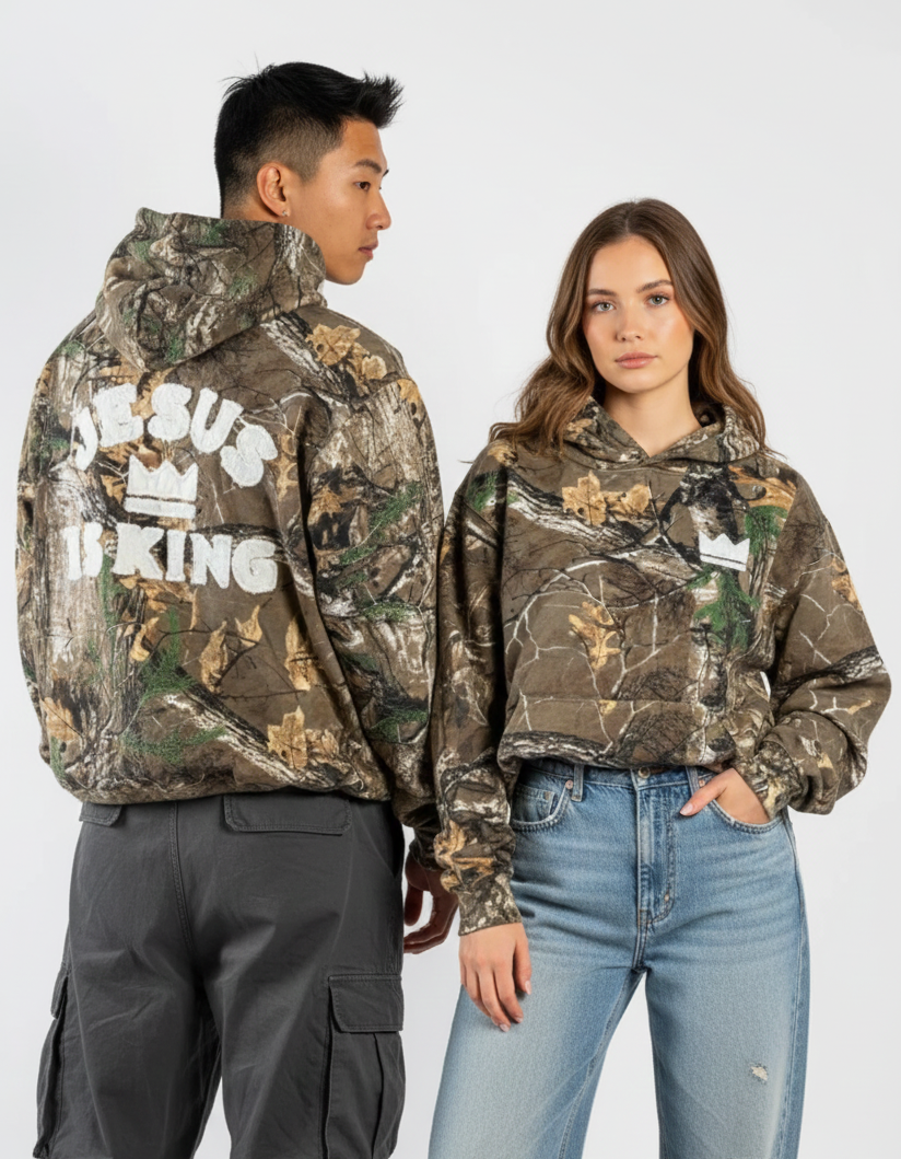 Two people wearing camouflage hoodies with text on a white background